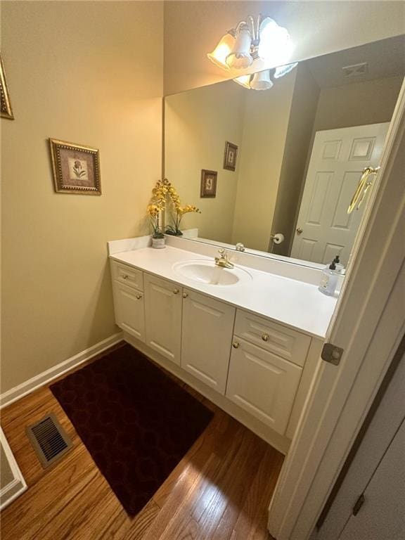 bathroom featuring hardwood / wood-style flooring, vanity, and an inviting chandelier