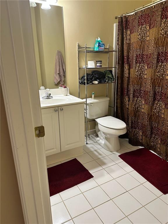 bathroom with tile patterned flooring, vanity, and toilet