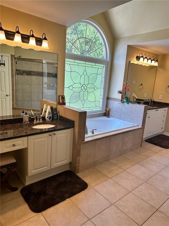 bathroom with tile patterned flooring, lofted ceiling, vanity, and plus walk in shower