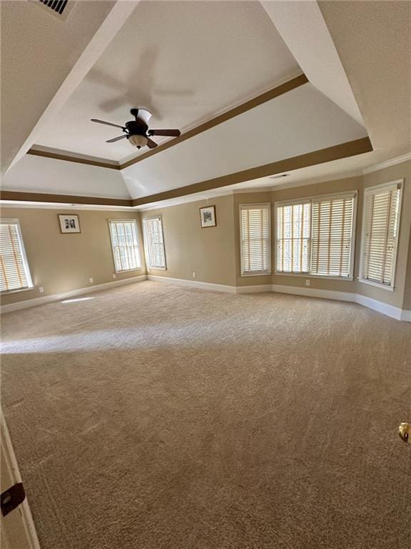 carpeted spare room featuring a raised ceiling, ceiling fan, and crown molding