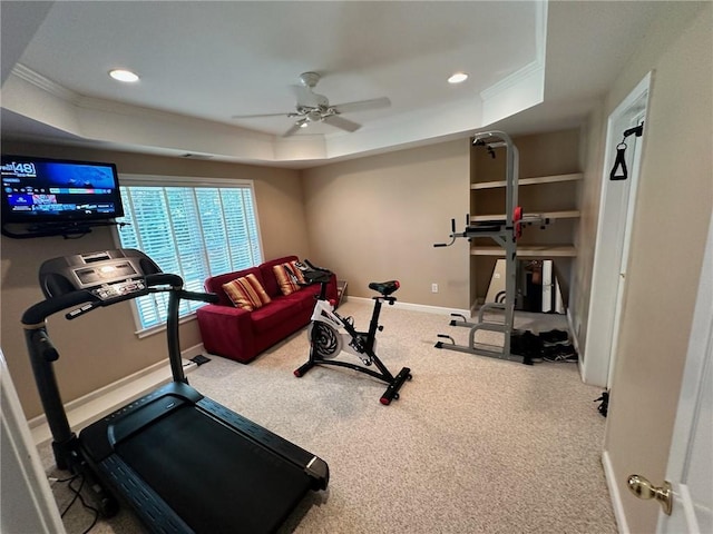 exercise room with carpet, ceiling fan, and a tray ceiling