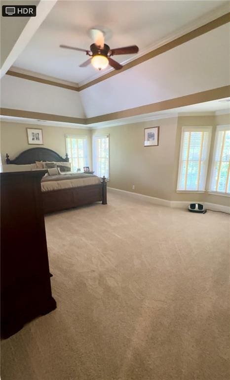 carpeted bedroom with ceiling fan, a raised ceiling, crown molding, and vaulted ceiling