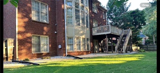 rear view of house with a yard and a wooden deck