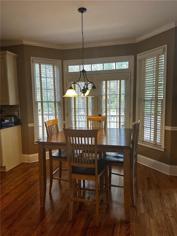 dining room with a healthy amount of sunlight, ornamental molding, dark wood-type flooring, and a chandelier