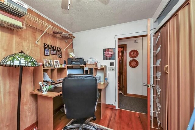 office with wood walls, crown molding, a textured ceiling, and ceiling fan