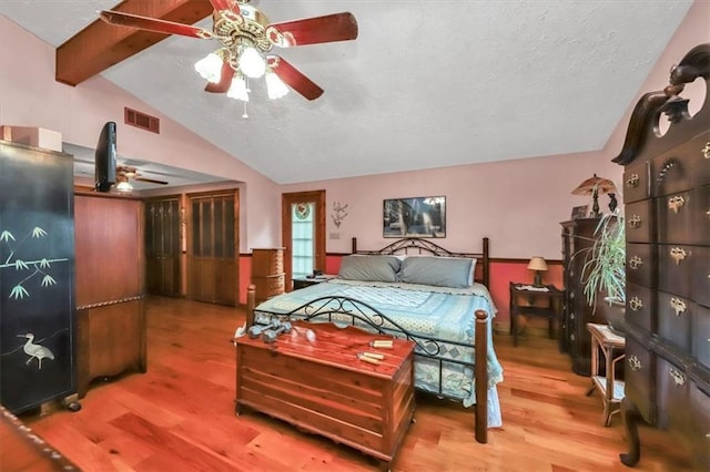 bedroom with lofted ceiling with beams, wood-type flooring, and ceiling fan