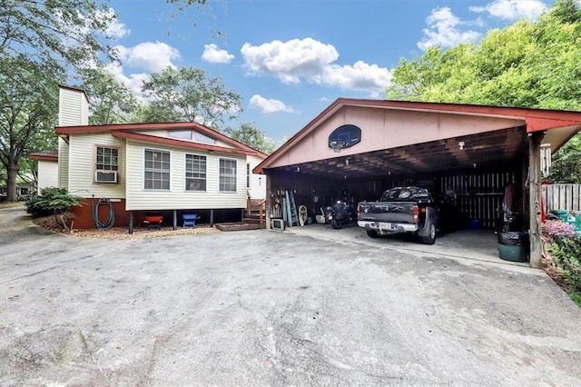 view of parking with driveway and a carport