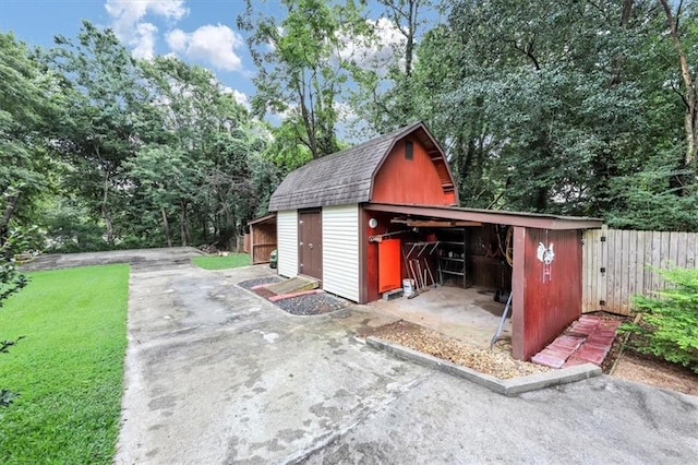 view of outdoor structure featuring an outbuilding and fence