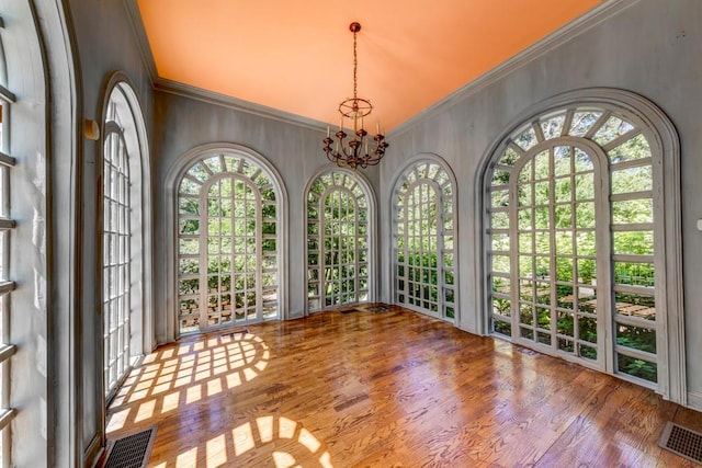 unfurnished sunroom with plenty of natural light and a notable chandelier