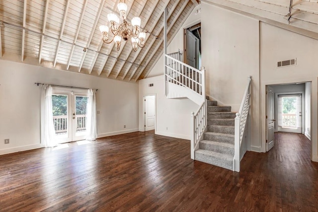 unfurnished living room with french doors, dark hardwood / wood-style flooring, an inviting chandelier, high vaulted ceiling, and beamed ceiling