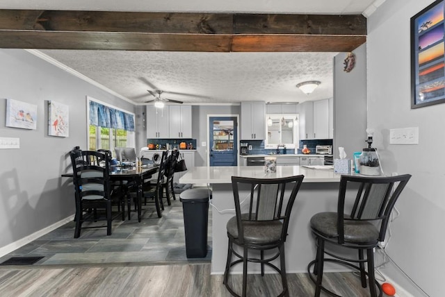 1467 Hewatt Rd, Lilburn, GA 30047 - dining space with a ceiling fan, baseboards, crown molding, and dark wood-style flooring