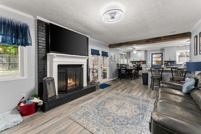 1467 Hewatt Rd, Lilburn, GA 30047 - living area featuring a textured ceiling, ornamental molding, wood finished floors, a fireplace, and beamed ceiling