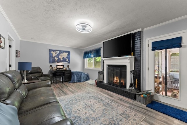 1467 Hewatt Rd, Lilburn, GA 30047 - living room with wood finished floors, a textured ceiling, a brick fireplace, and ornamental molding