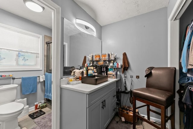1467 Hewatt Rd, Lilburn, GA 30047 - bathroom featuring toilet, vanity, an enclosed shower, a textured ceiling, and baseboards
