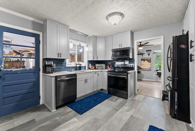 1467 Hewatt Rd, Lilburn, GA 30047 - kitchen featuring stainless steel appliances, a sink, ceiling fan, decorative backsplash, and light countertops