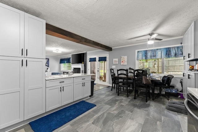 1467 Hewatt Rd, Lilburn, GA 30047 - kitchen with ceiling fan, light countertops, a textured ceiling, beam ceiling, and a peninsula