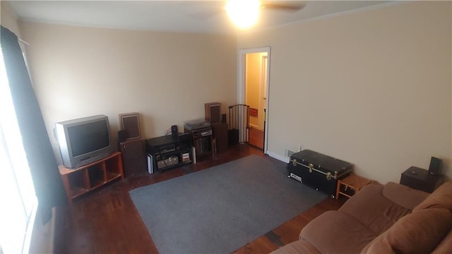 living room with dark wood-type flooring and ceiling fan