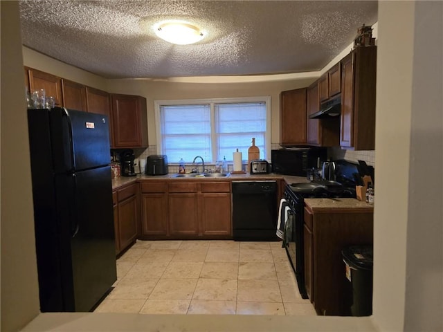 kitchen with tasteful backsplash, sink, light tile patterned floors, black appliances, and a textured ceiling