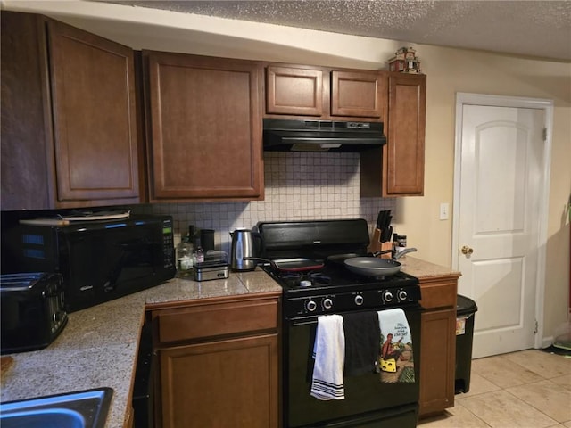 kitchen with sink, black appliances, a textured ceiling, light tile patterned flooring, and decorative backsplash