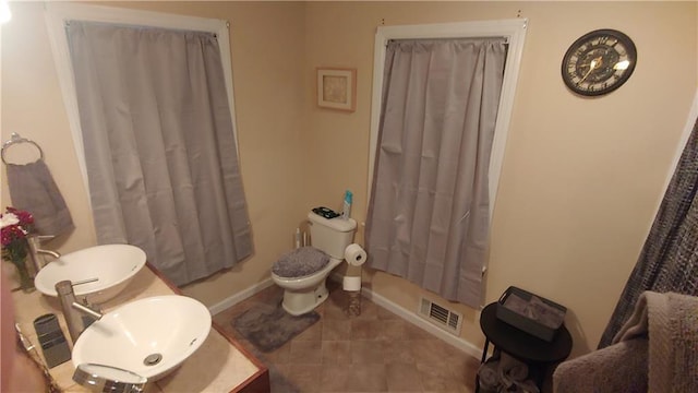 bathroom with tile patterned flooring, vanity, and toilet