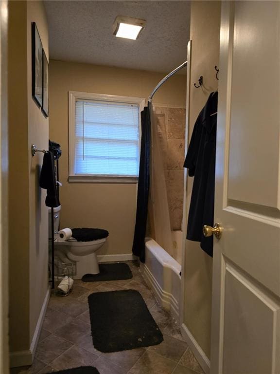 bathroom with shower / tub combo with curtain, toilet, and a textured ceiling