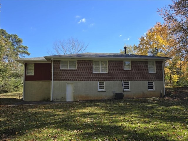 rear view of property featuring a yard and central AC unit