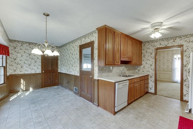 kitchen featuring ceiling fan with notable chandelier, dishwasher, pendant lighting, and sink