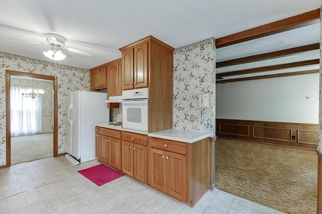 kitchen featuring white appliances, light carpet, ceiling fan with notable chandelier, and beam ceiling