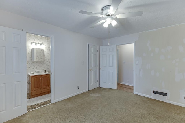 unfurnished bedroom featuring ensuite bath, ceiling fan, light carpet, and sink