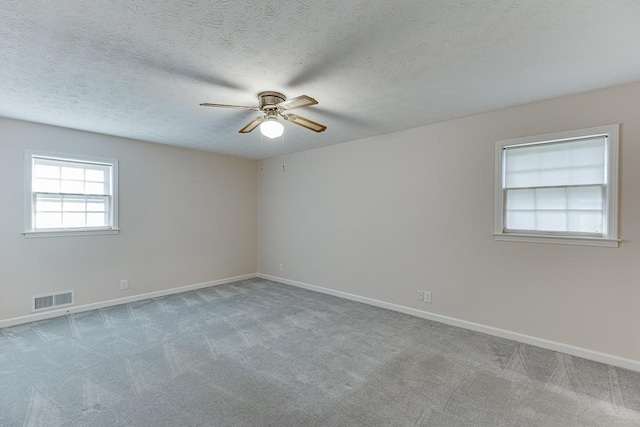 unfurnished room featuring light colored carpet, ceiling fan, and a textured ceiling