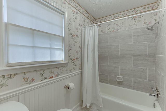 bathroom featuring toilet, a textured ceiling, and shower / bath combination with curtain