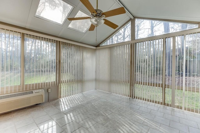 unfurnished sunroom with a wall mounted air conditioner, ceiling fan, and vaulted ceiling with skylight