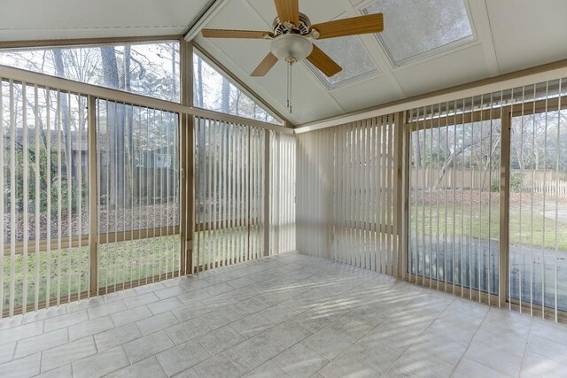 unfurnished sunroom featuring lofted ceiling, ceiling fan, and a wealth of natural light