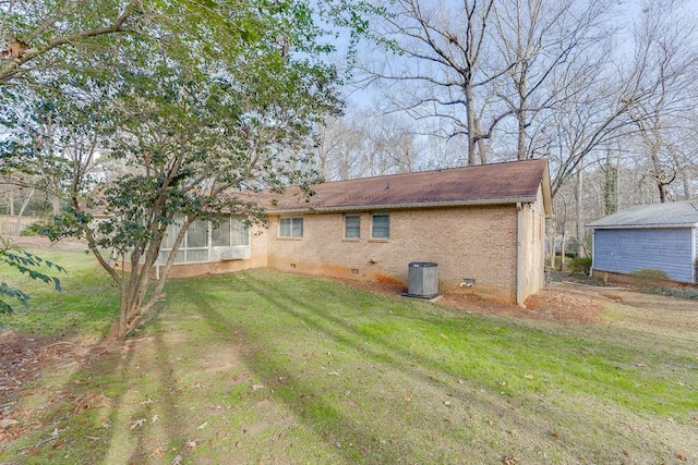 rear view of house featuring cooling unit and a lawn