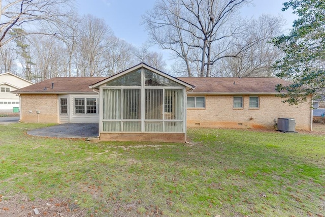 rear view of house featuring a patio area, central air condition unit, a sunroom, and a lawn