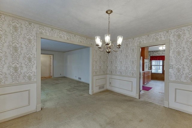 unfurnished dining area featuring a textured ceiling, crown molding, light carpet, and a chandelier