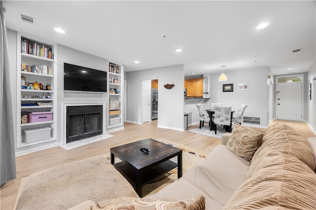 472 Sherman Way, Decatur, GA 30033 - living room featuring a fireplace with flush hearth, light wood-type flooring, recessed lighting, baseboards, and built in shelves