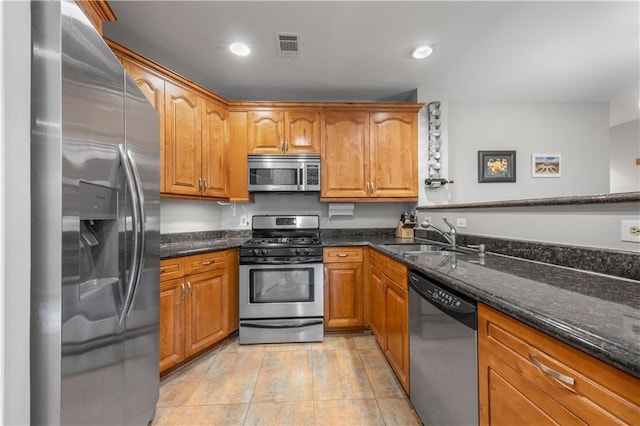 472 Sherman Way, Decatur, GA 30033 - kitchen featuring stainless steel appliances, a sink, dark stone countertops, brown cabinets, and recessed lighting