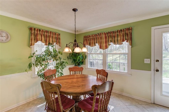 dining room with an inviting chandelier, crown molding, and light tile patterned flooring