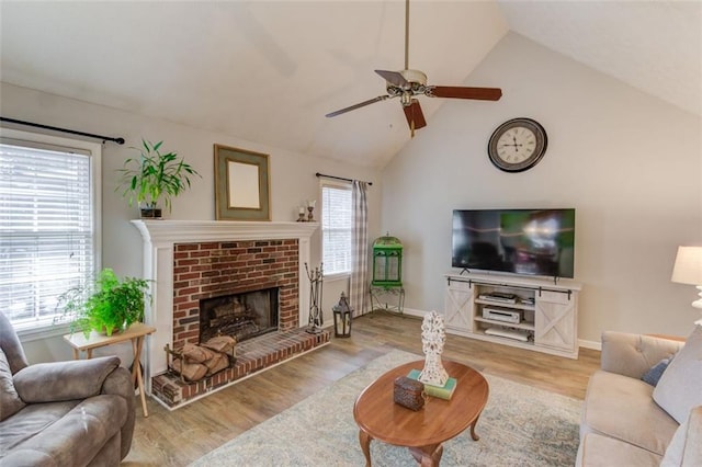 living area featuring a wealth of natural light, a fireplace, and wood finished floors