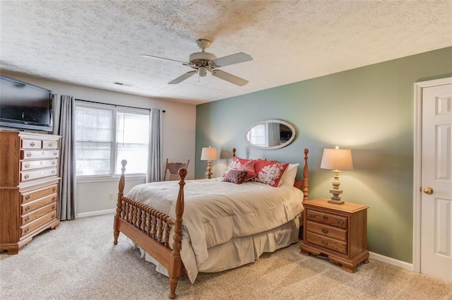 bedroom with light colored carpet, visible vents, baseboards, and a textured ceiling