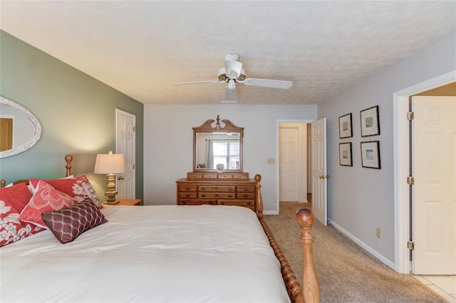 carpeted bedroom featuring ceiling fan, a textured ceiling, and baseboards