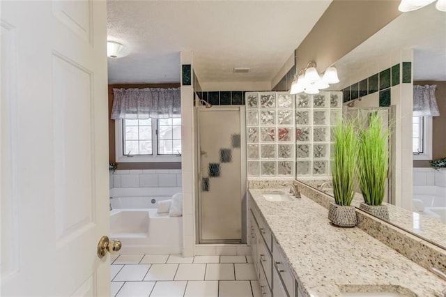 bathroom with double vanity, a stall shower, a bath, tile patterned floors, and a sink