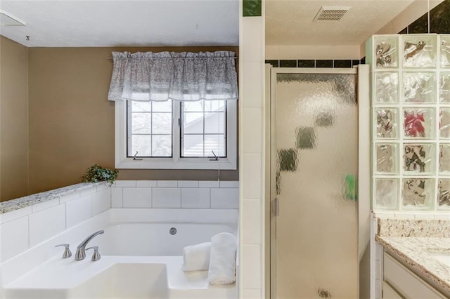 bathroom featuring a garden tub, visible vents, a stall shower, vanity, and a textured ceiling