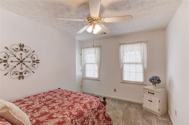 bedroom featuring visible vents, light colored carpet, ceiling fan, a textured ceiling, and baseboards