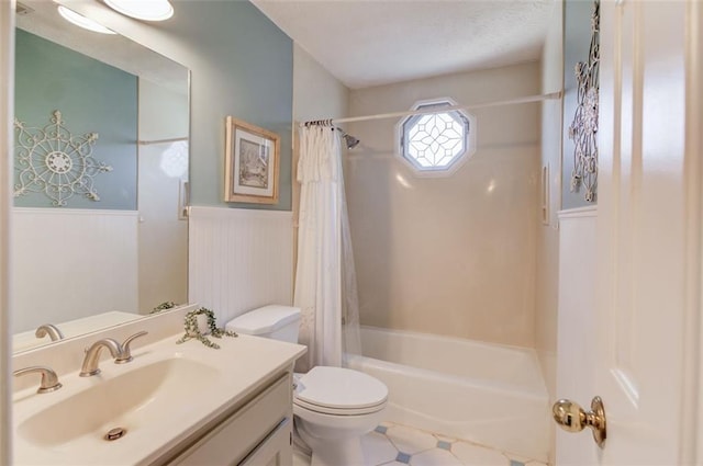 full bath featuring a wainscoted wall, shower / tub combo, vanity, and toilet