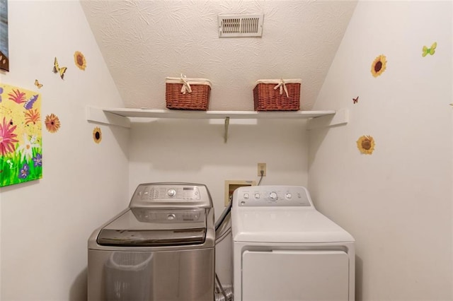 clothes washing area featuring washer and dryer, laundry area, and visible vents