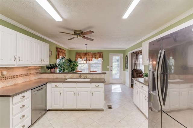 kitchen featuring stainless steel appliances, white cabinets, a sink, and a peninsula