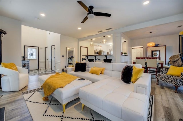 living room with ceiling fan and light wood-type flooring