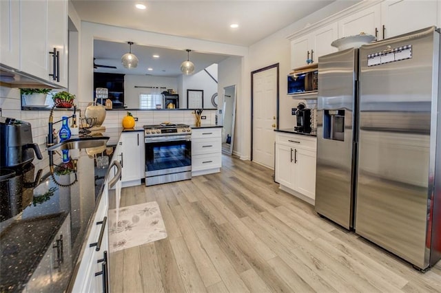 kitchen with stainless steel appliances, tasteful backsplash, hanging light fixtures, and white cabinetry